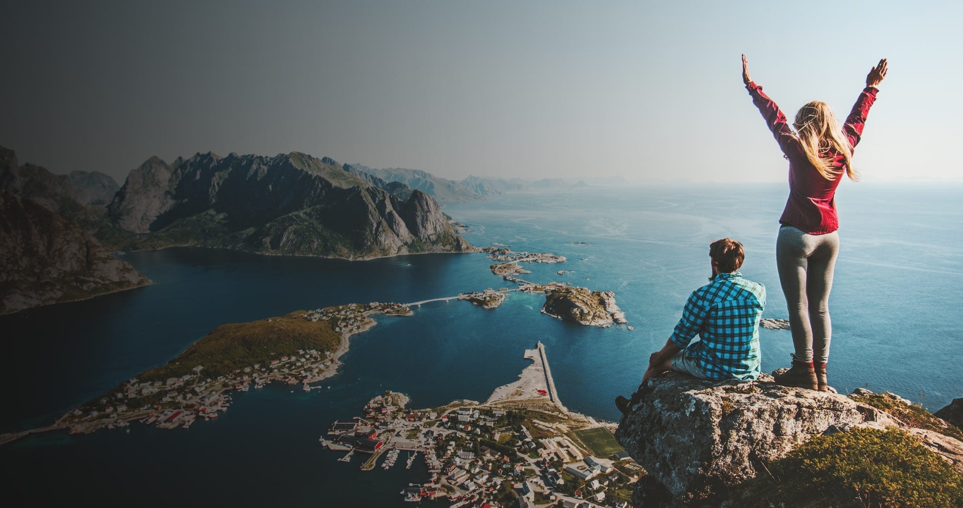 Image of couple standing on top of rock cliff